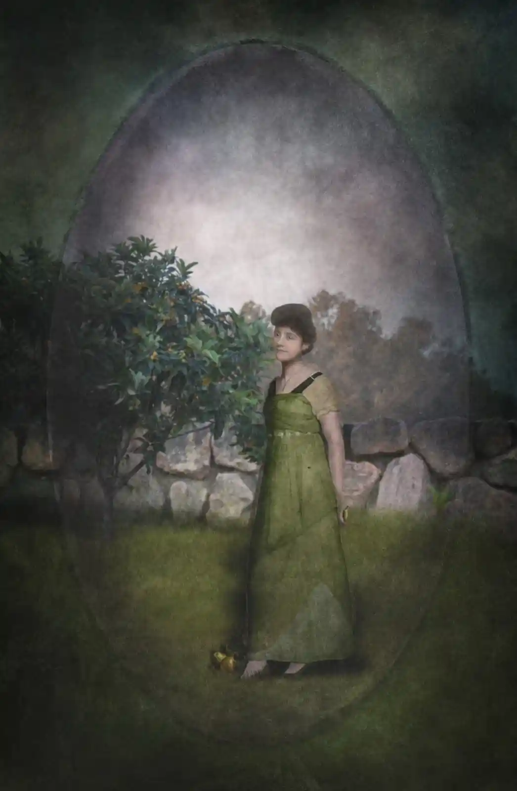 A young woman in a flowing green dress stands in a garden framed by a stone wall, her expression pensive. She holds a small object, possibly a lemon, as orange fruits dangle from a nearby tree. A hazy oval frame adds a dream-like quality, the scene suggesting secrets hidden in the foliage and the muted colors of a memory just out of reach.