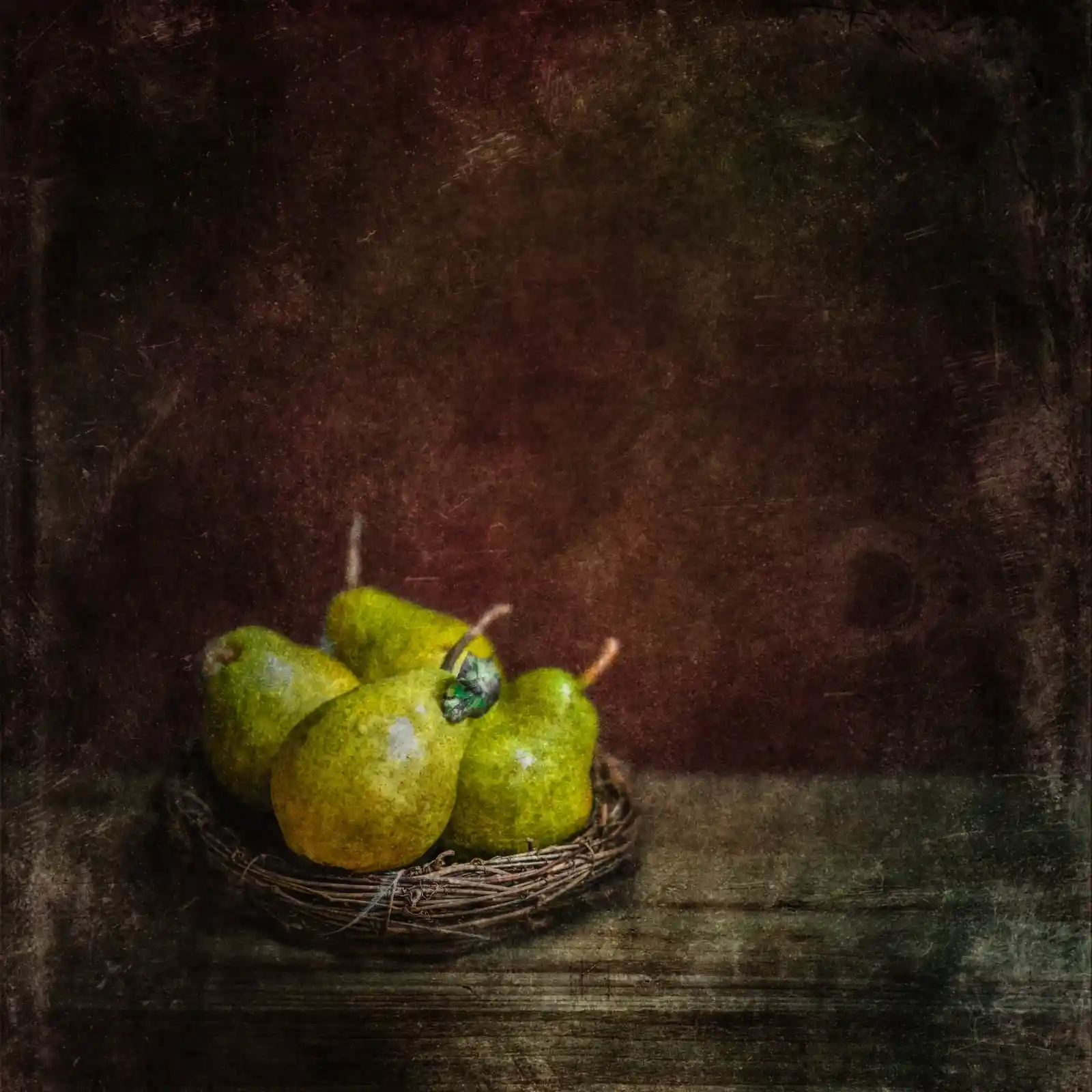 Five golden pears rest in a delicate wicker nest atop a weathered table. The soft, dappled light catches on their slightly bruised skin, revealing the subtle greens and yellows of their ripening flesh. Shadows cradle each curve, whispering of sweet decay and fleeting moments. It is a still life captured in the breath before the bite—a suspended second where the world waits.